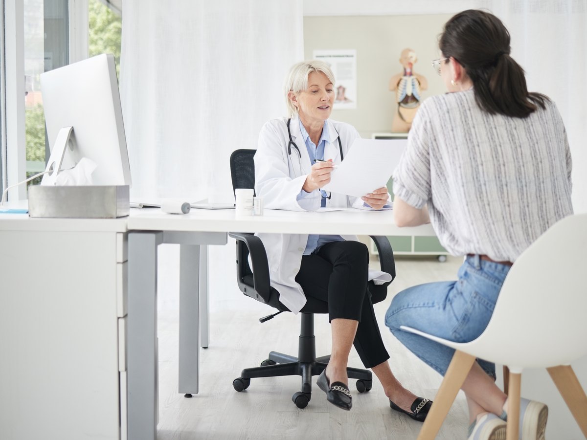 Médica explicando a una paciente los resultados de una analítica de zinc en consulta