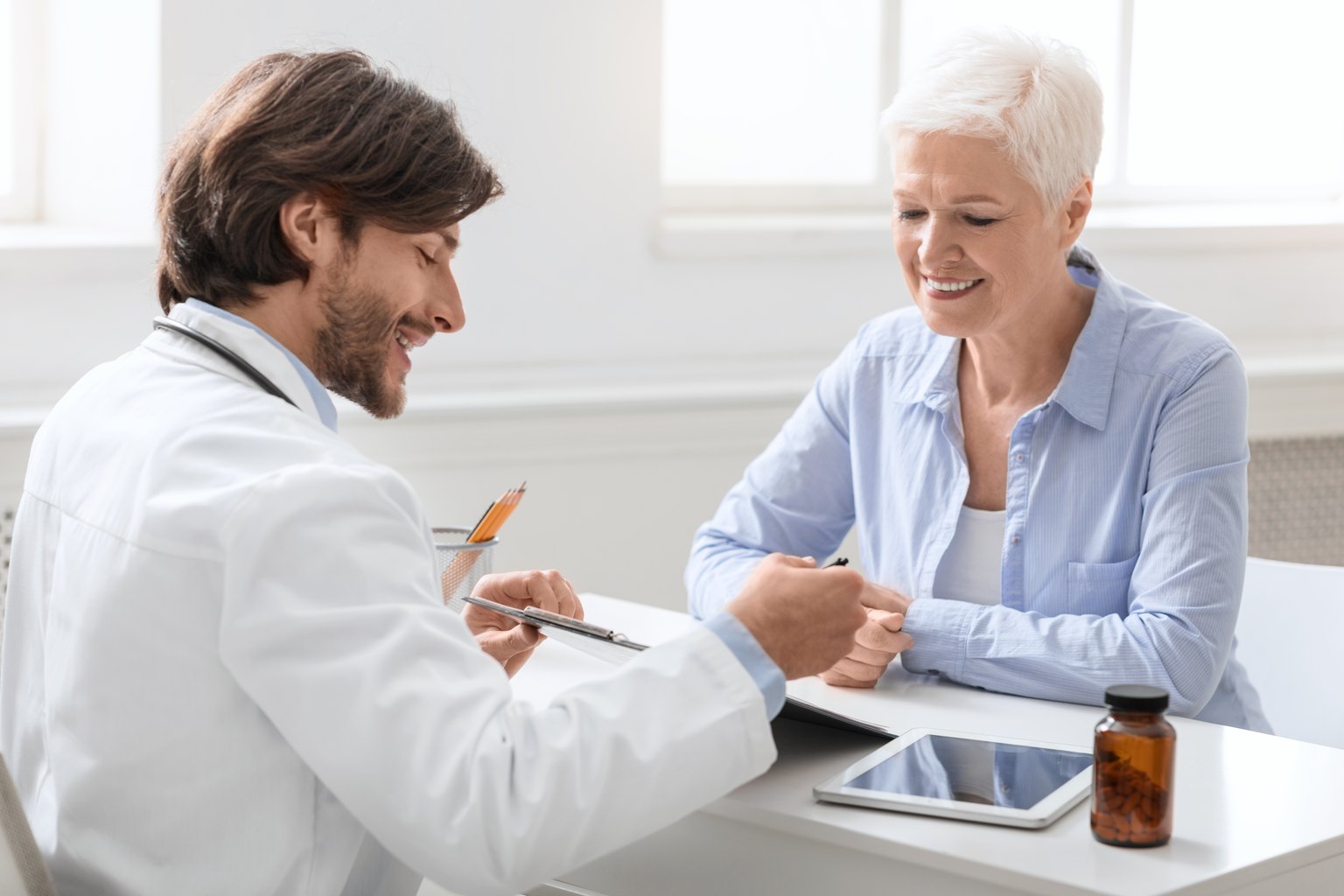 Médico revisando con una paciente madura su plan de tratamiento en la consulta