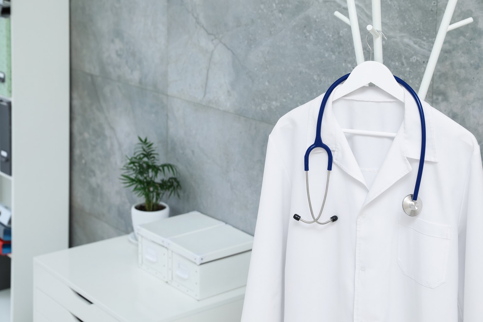 Bata médica blanca con estetoscopio colgada en la consulta