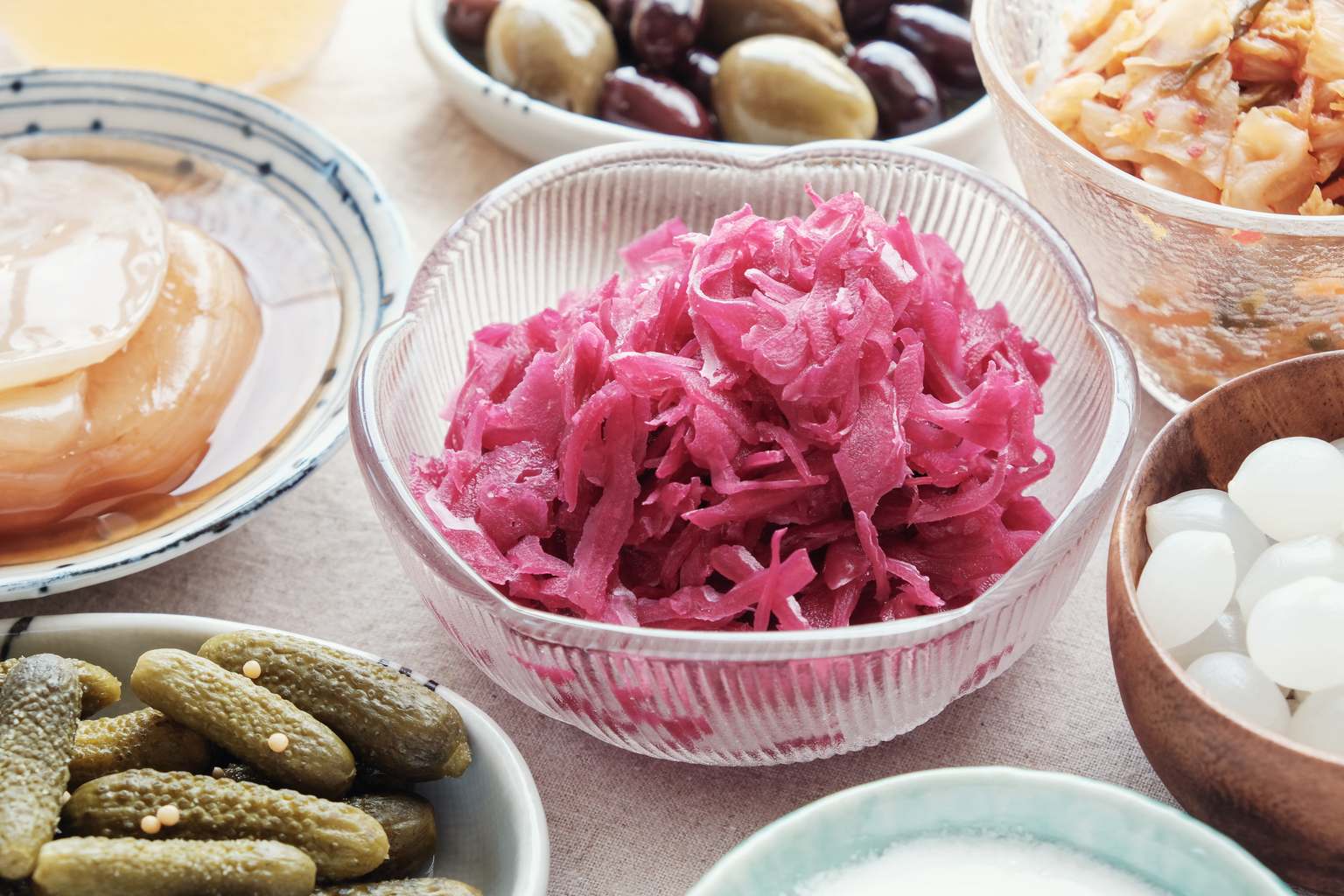 Cuencos con alimentos fermentados y probióticos: chucrut, pepinillos y kimchi
