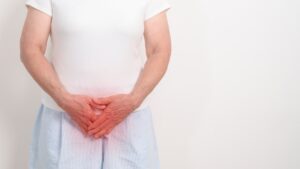 Mujer mayor con las manos sobre la pelvis por las molestias de la sequedad vaginal